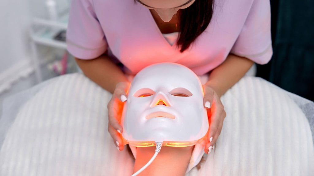 Woman wearing an LED red light therapy mask for at-home skin treatment